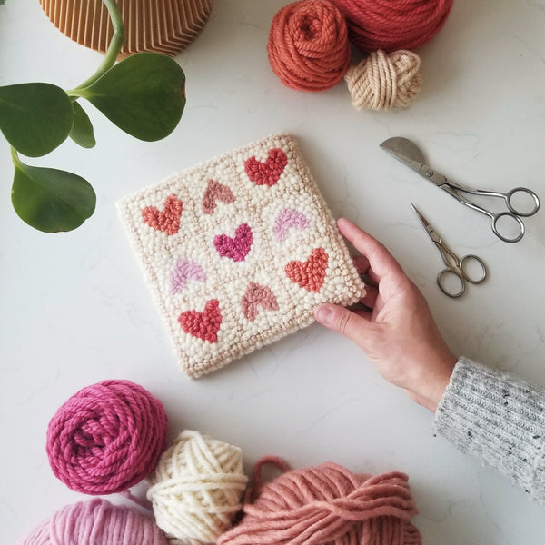 completed punch needle design with 9 hearts on it
