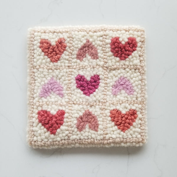 completed wool punch needle design with 9 hearts in a grid